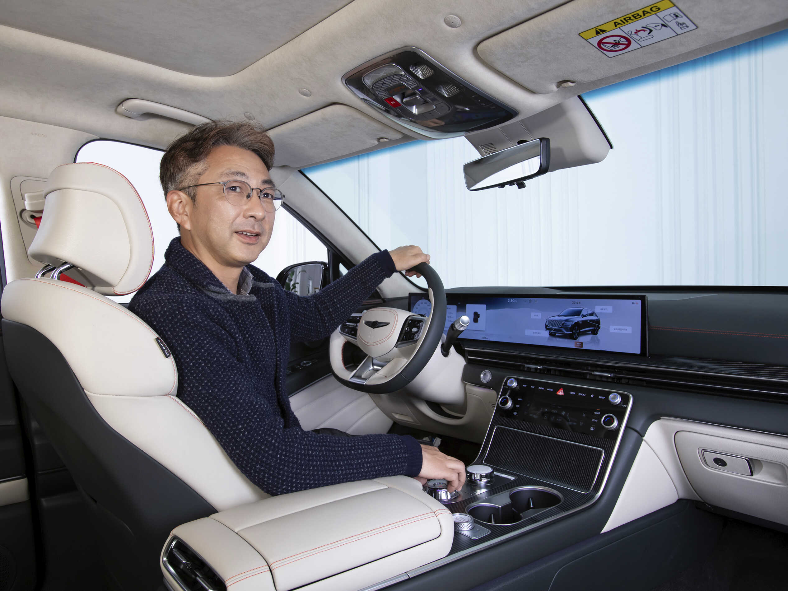 Senior researcher Jung-won Kim explaining the interior design of the GV80 while sitting in the driver's seat