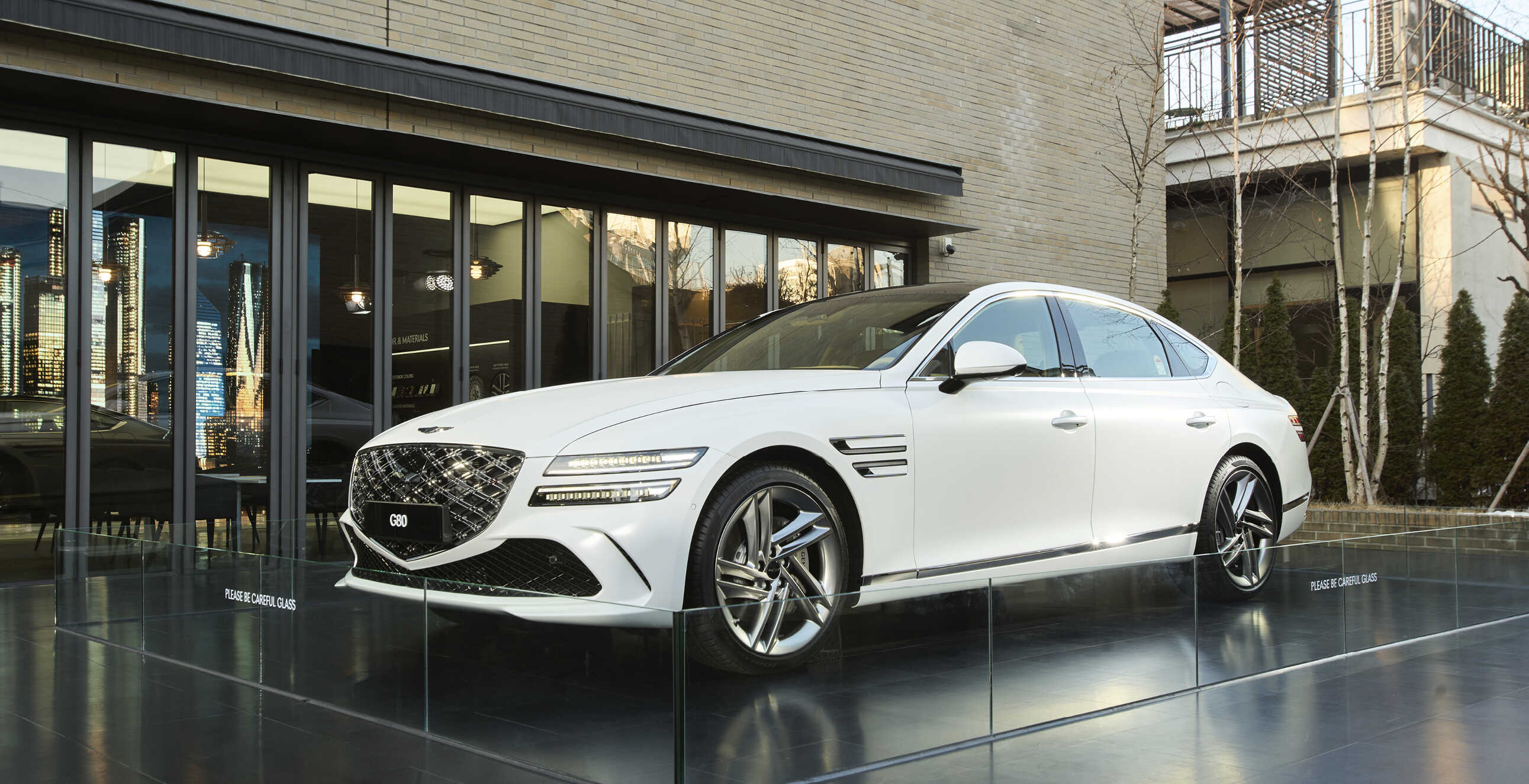 A white G80 standing in front of the exhibition hall