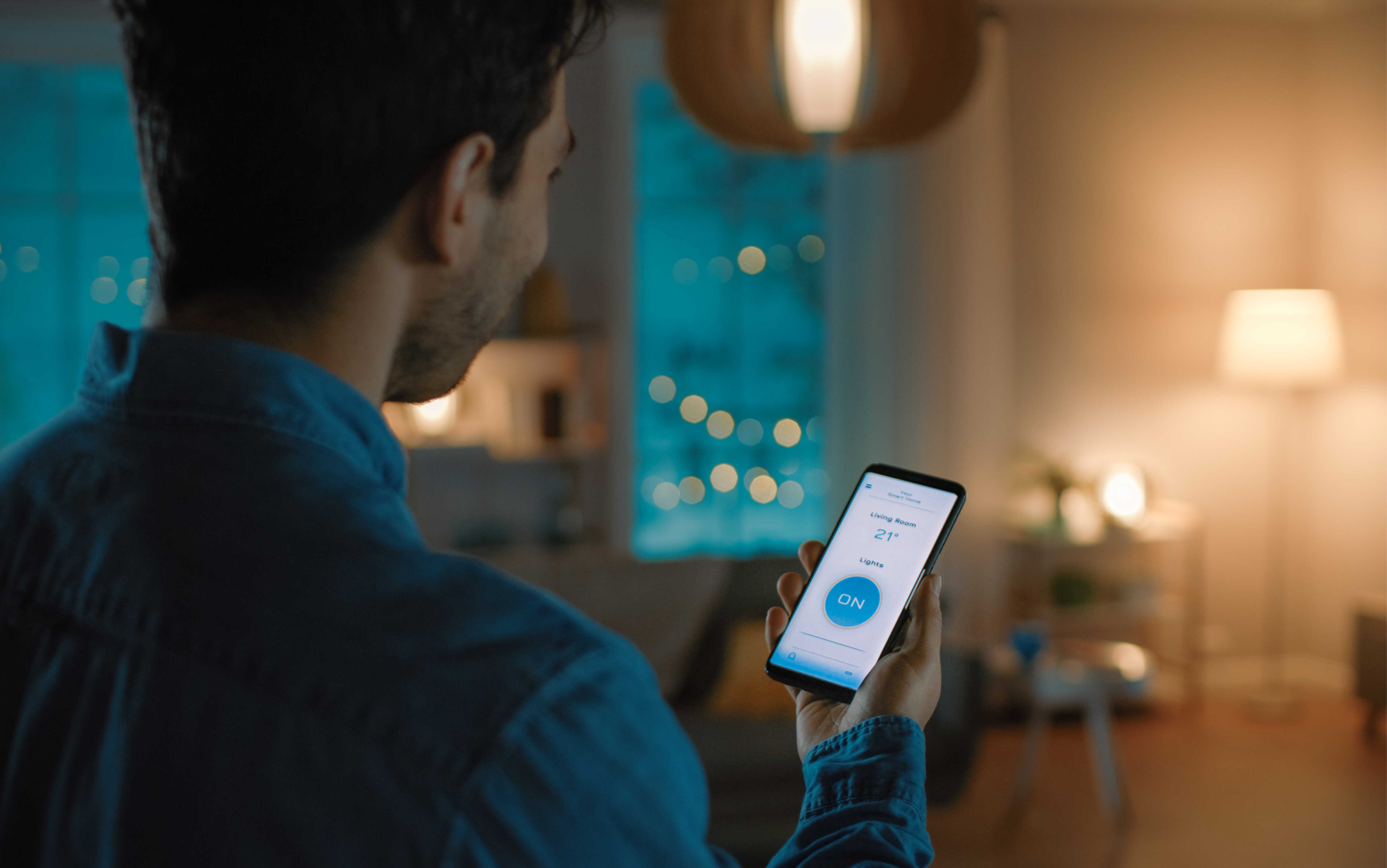 the image of a man adjusting the lighting with a smartphone