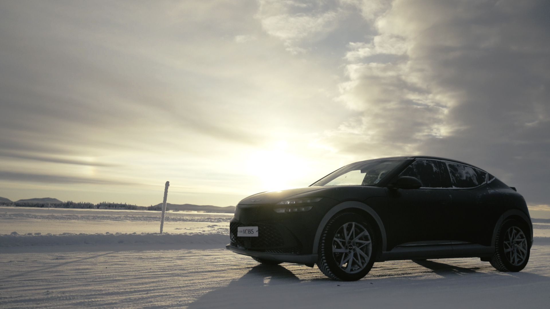 Test vehicle parked on a snowy field under the sunset sky