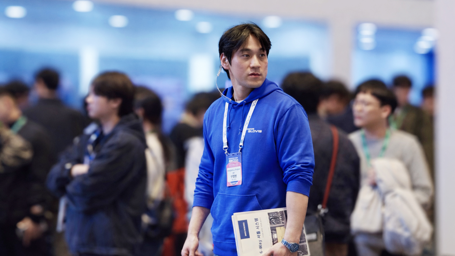 Staff member providing information at the Hyundai GLOVIS booth