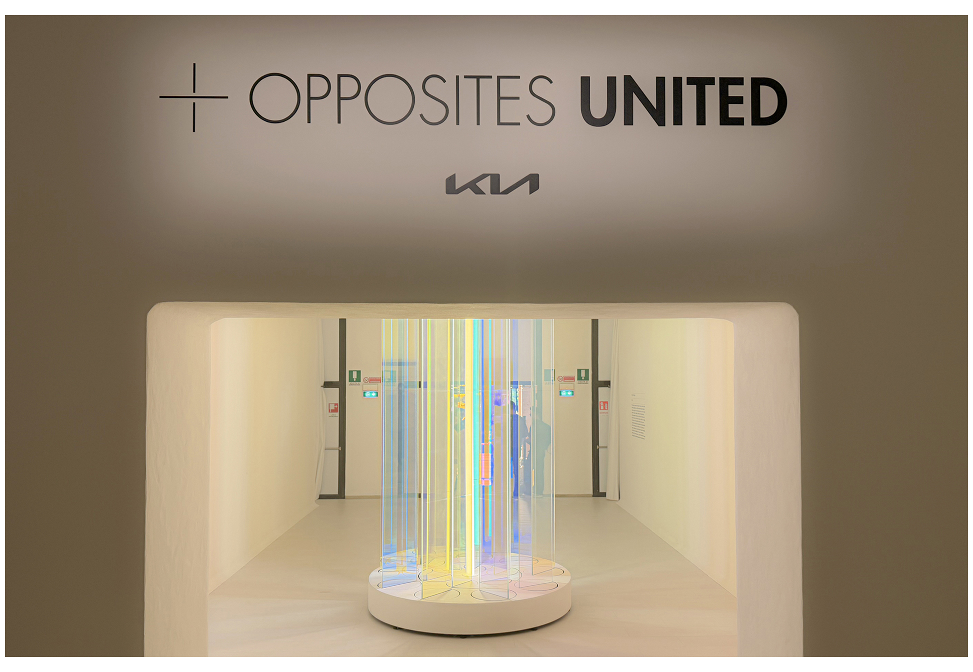 An 'Opposites United' lettering installation mounted on the entrance wall of an exhibition hall