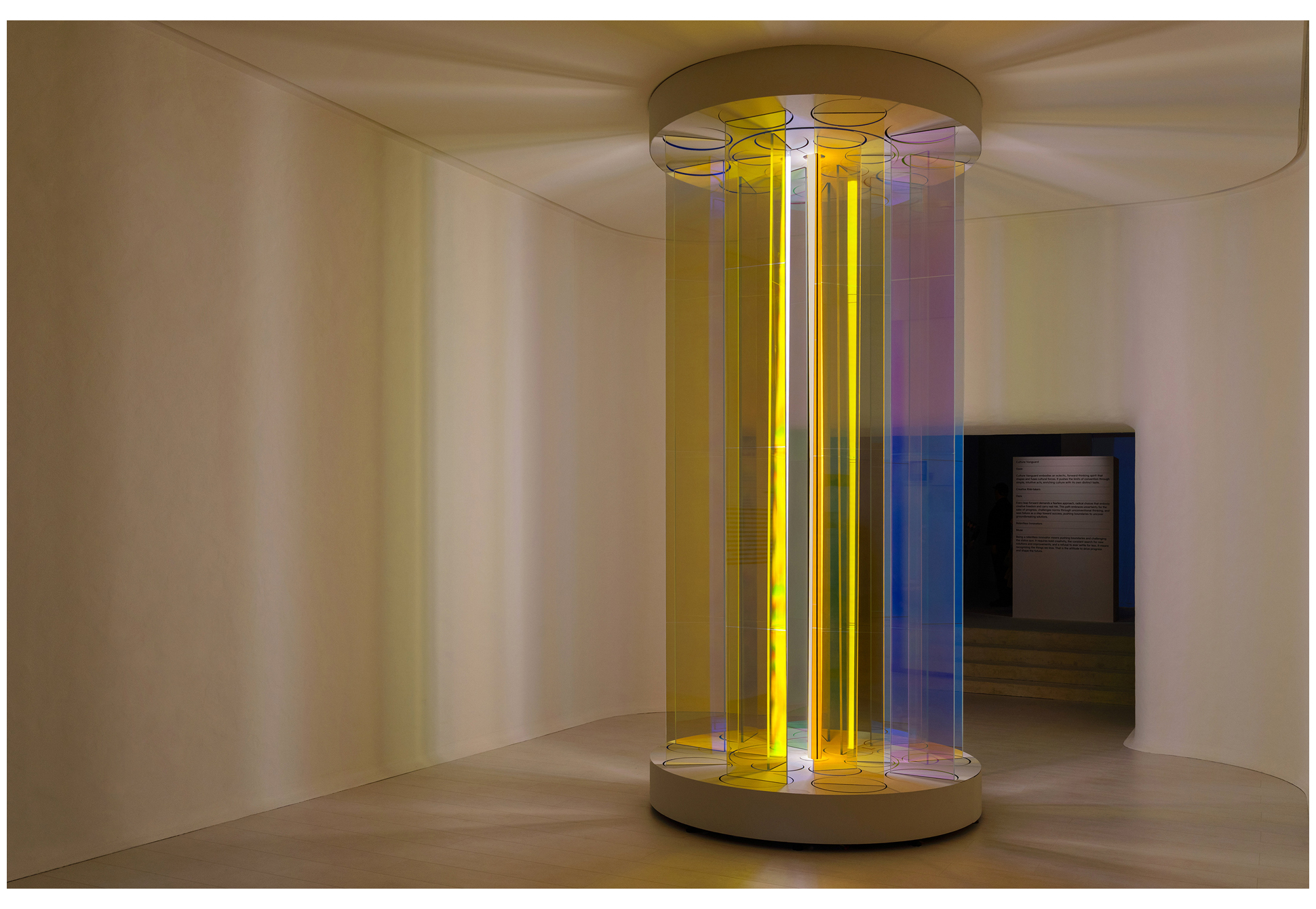 A minimalist exhibition space featuring cylindrical pillar-shaped light installations