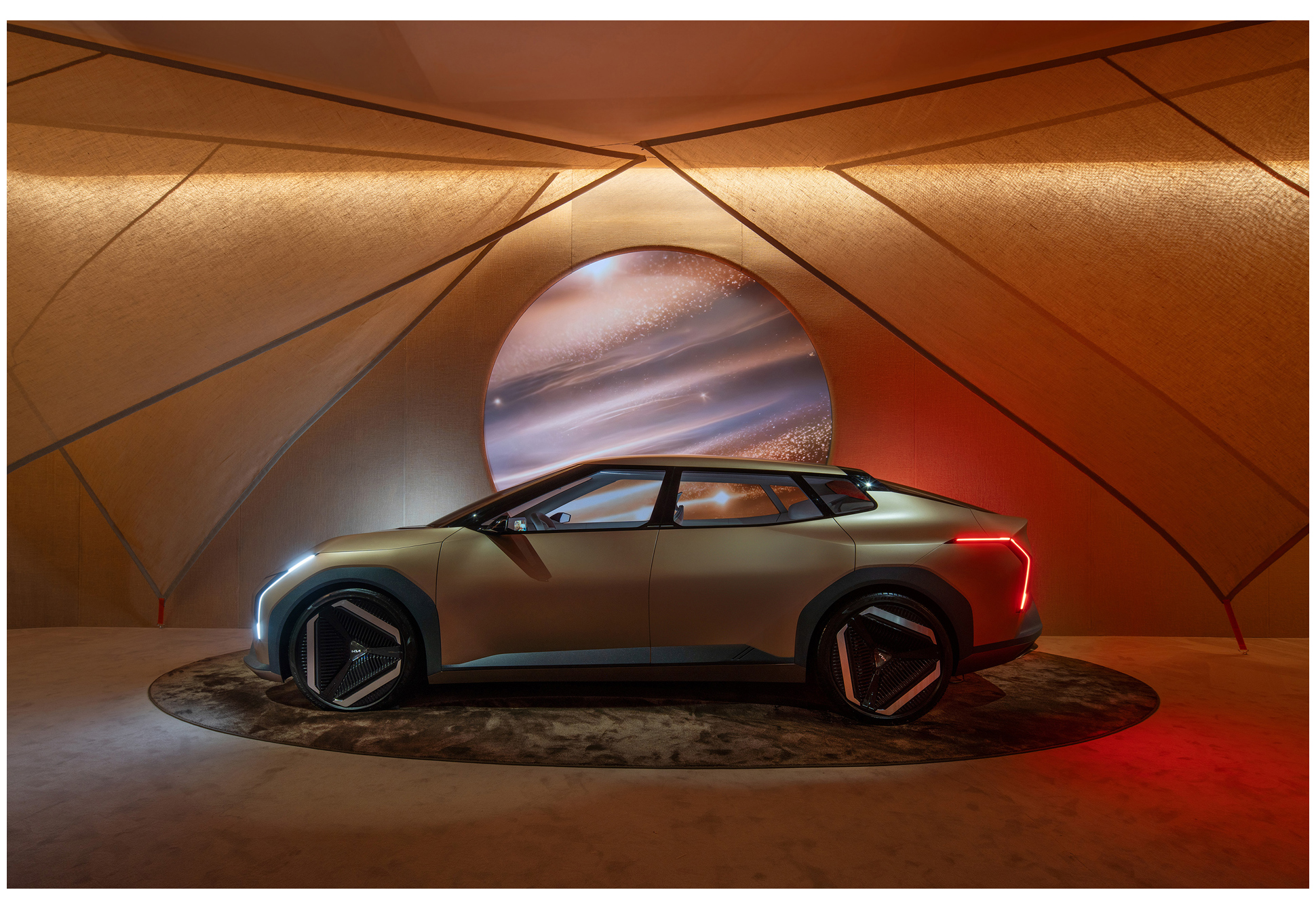 An exhibition scene with a circular digital graphic projected onto a vehicle's windshield (EV4)