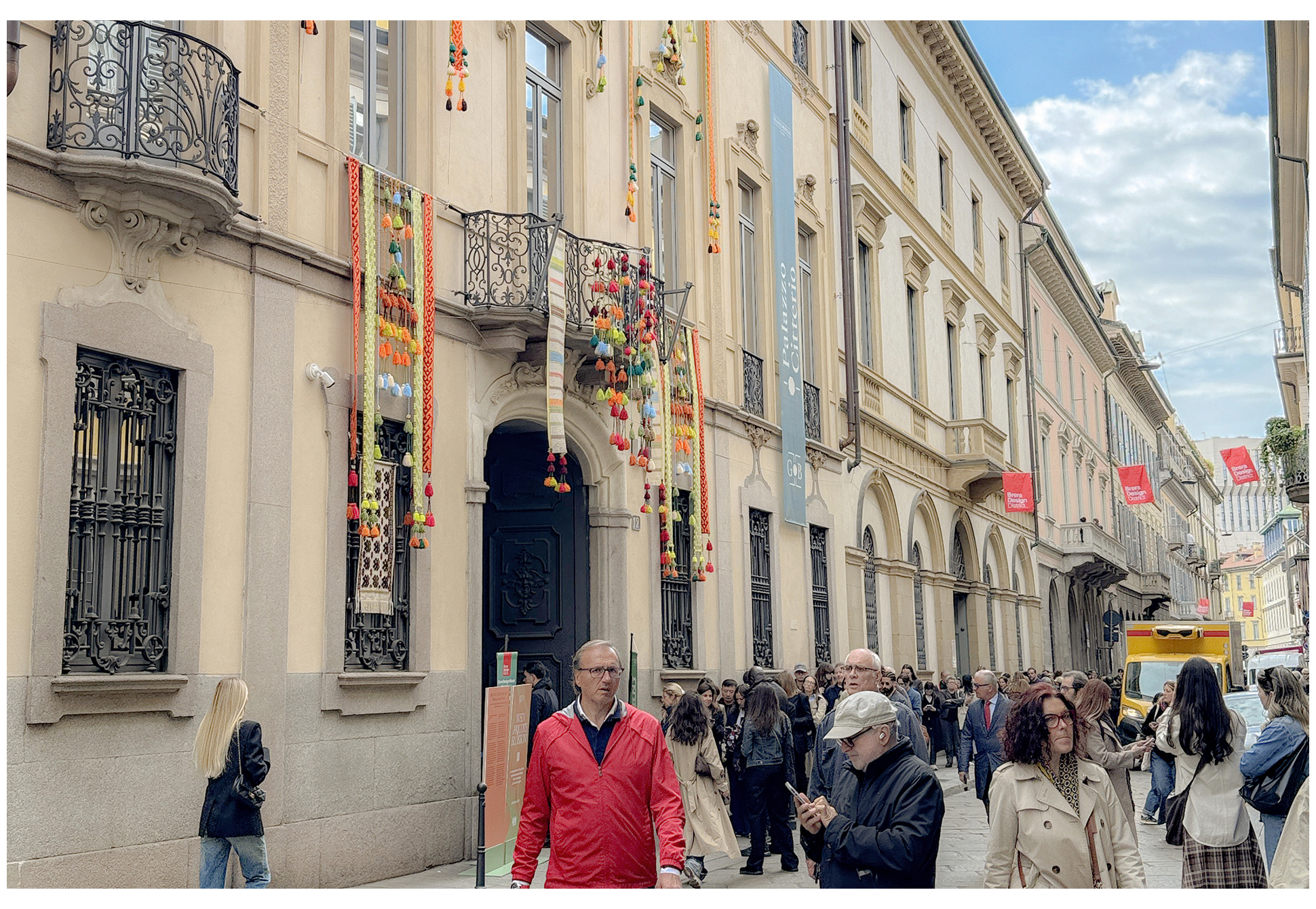 A lively Milan street scene with European-style buildings and pedestrians