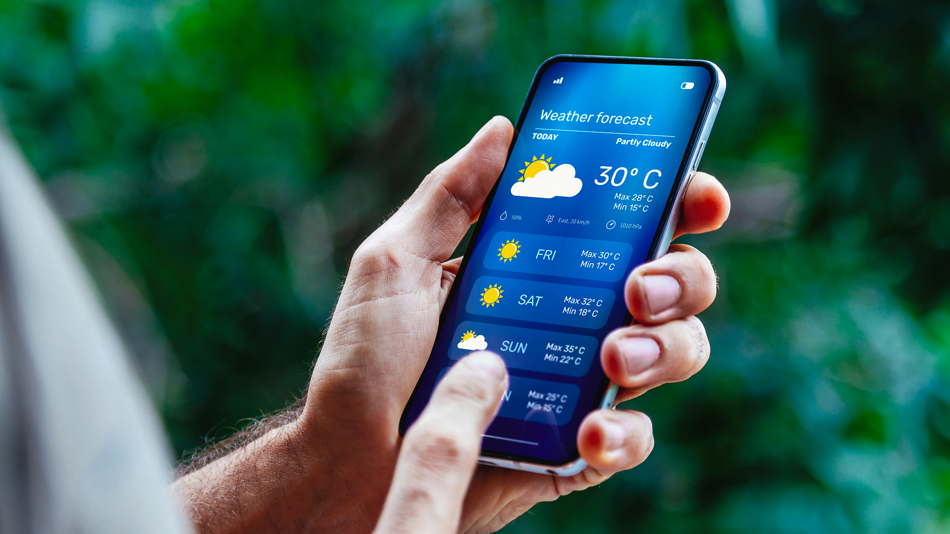 A close-up of a person's hand checking the weather on a smartphone