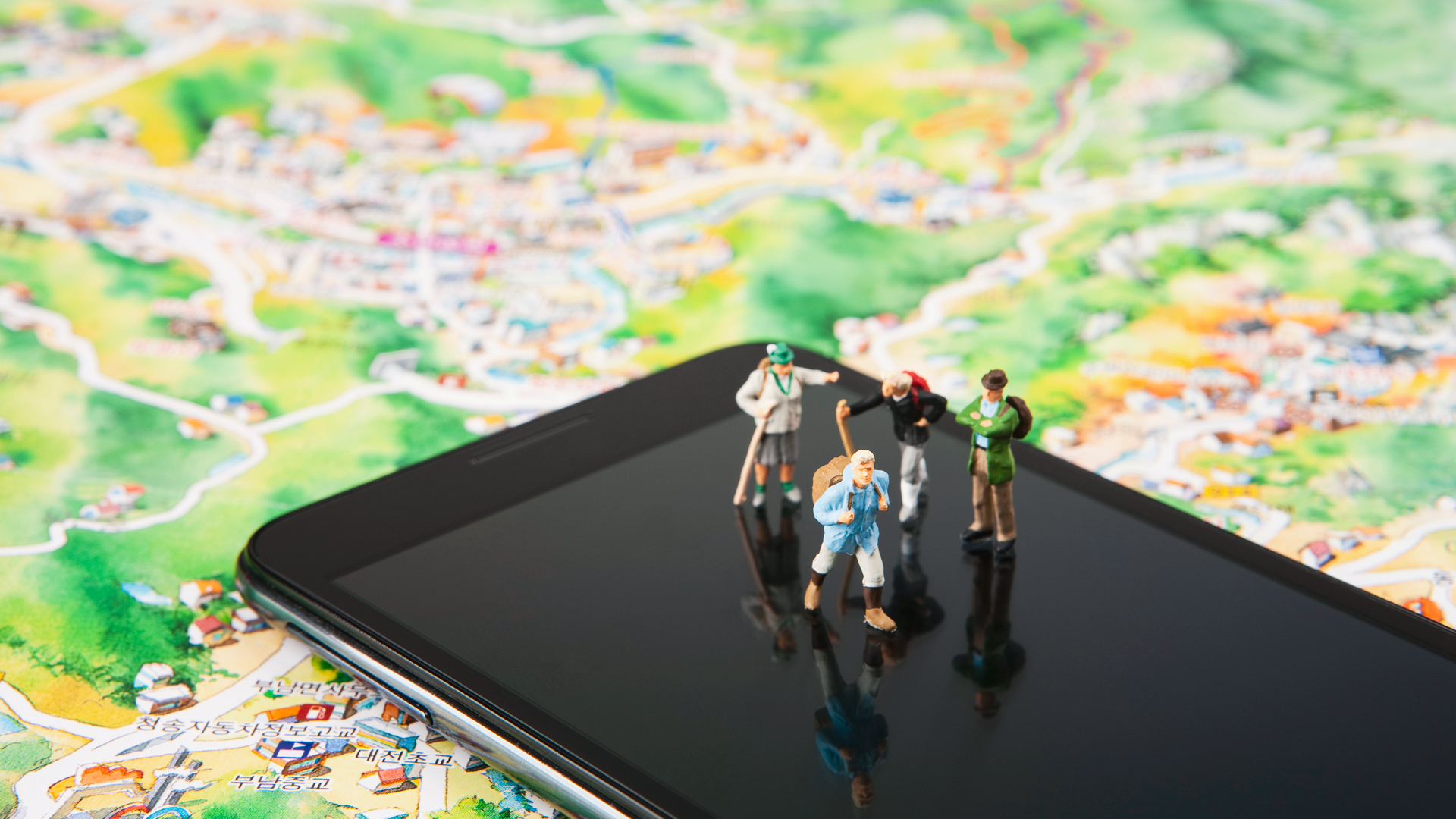 Miniature model image of four people standing on a map image