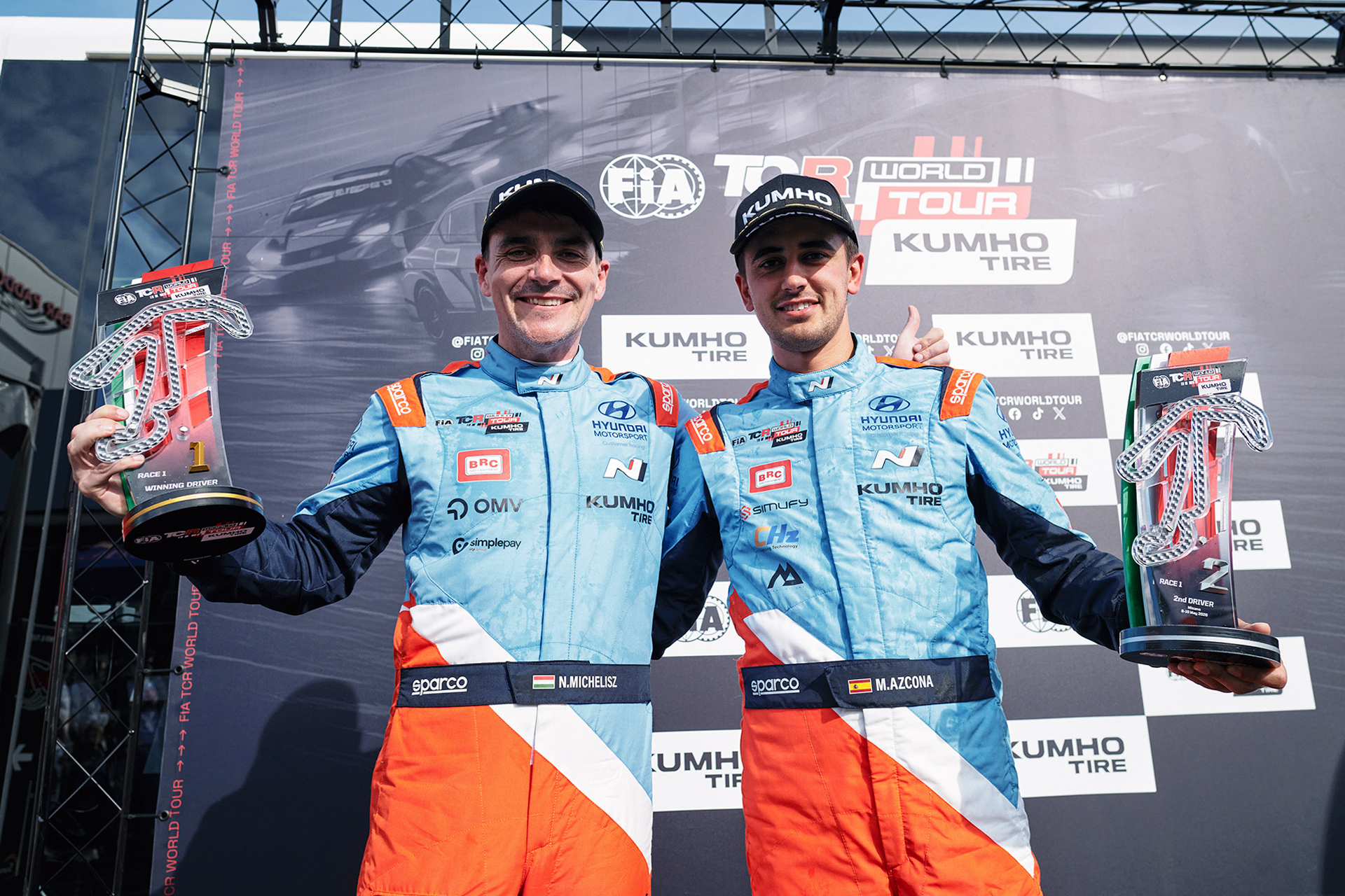 Norbert Michelisz (left) and Mikel Azcona (right) holding trophies in the pit area