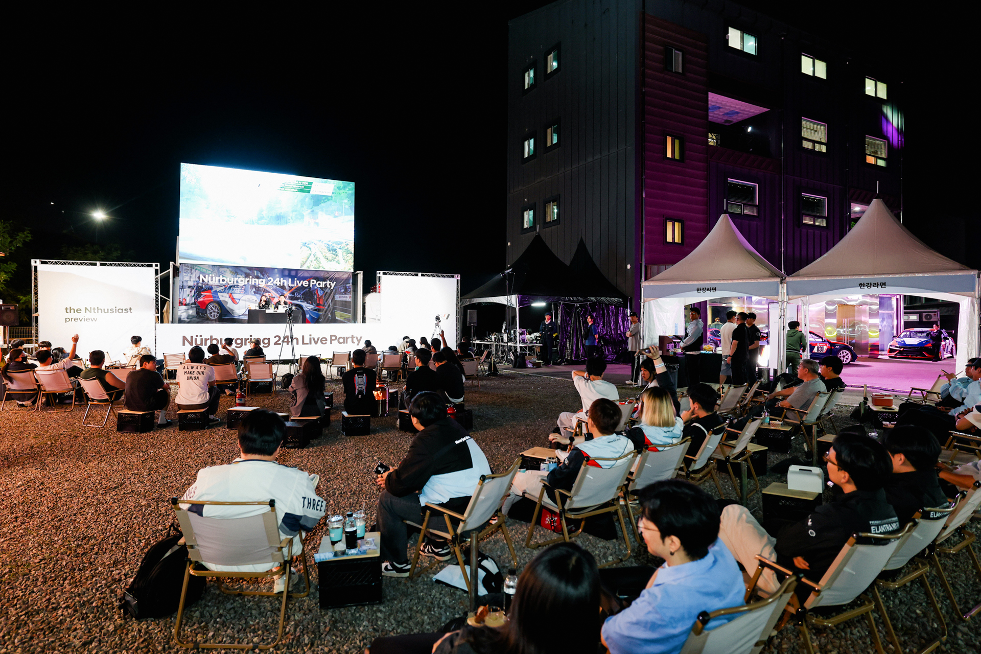 Spectators watching the Nürburgring 24 Hours race live on a large screen