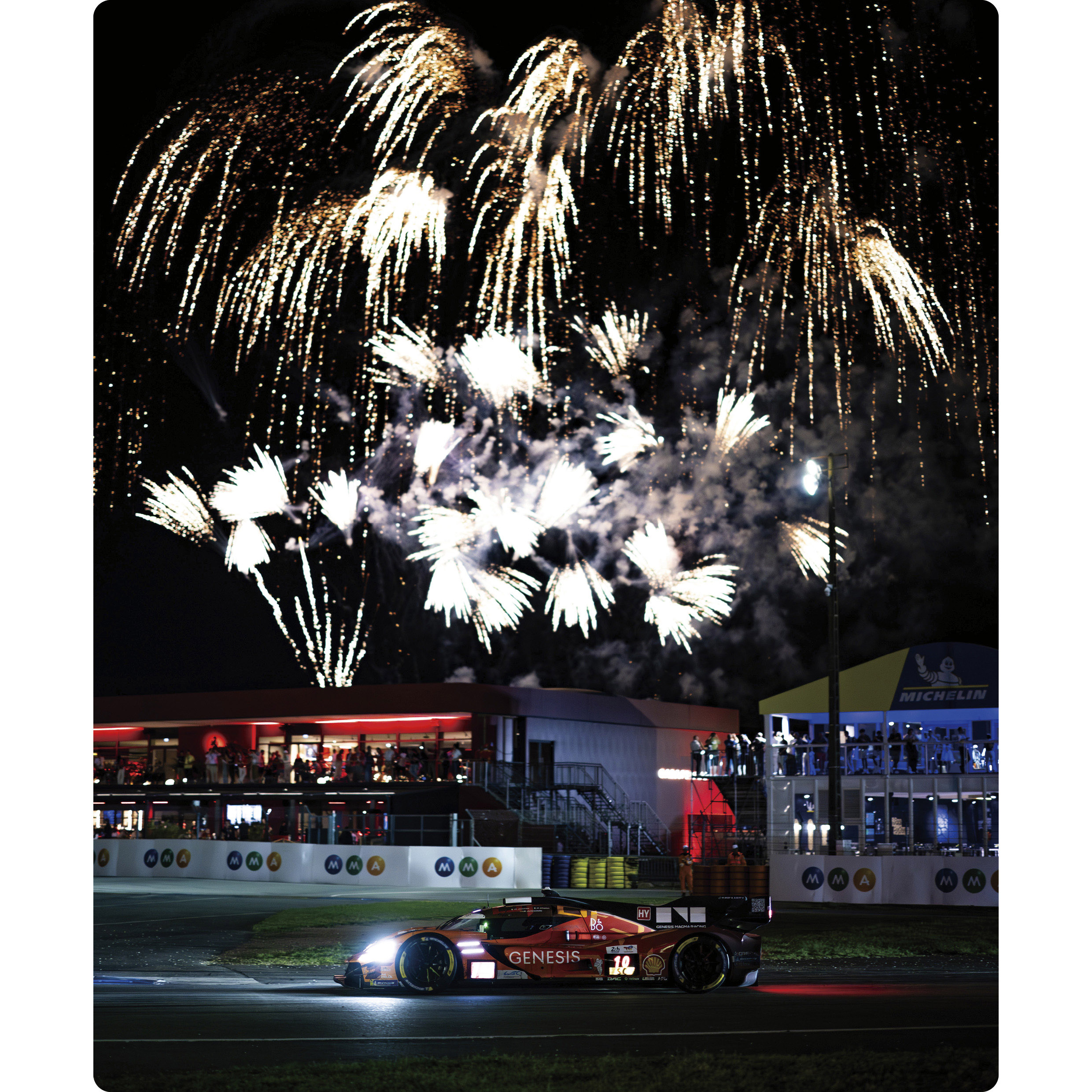 A Genesis hypercar driving under a night sky bursting with fireworks