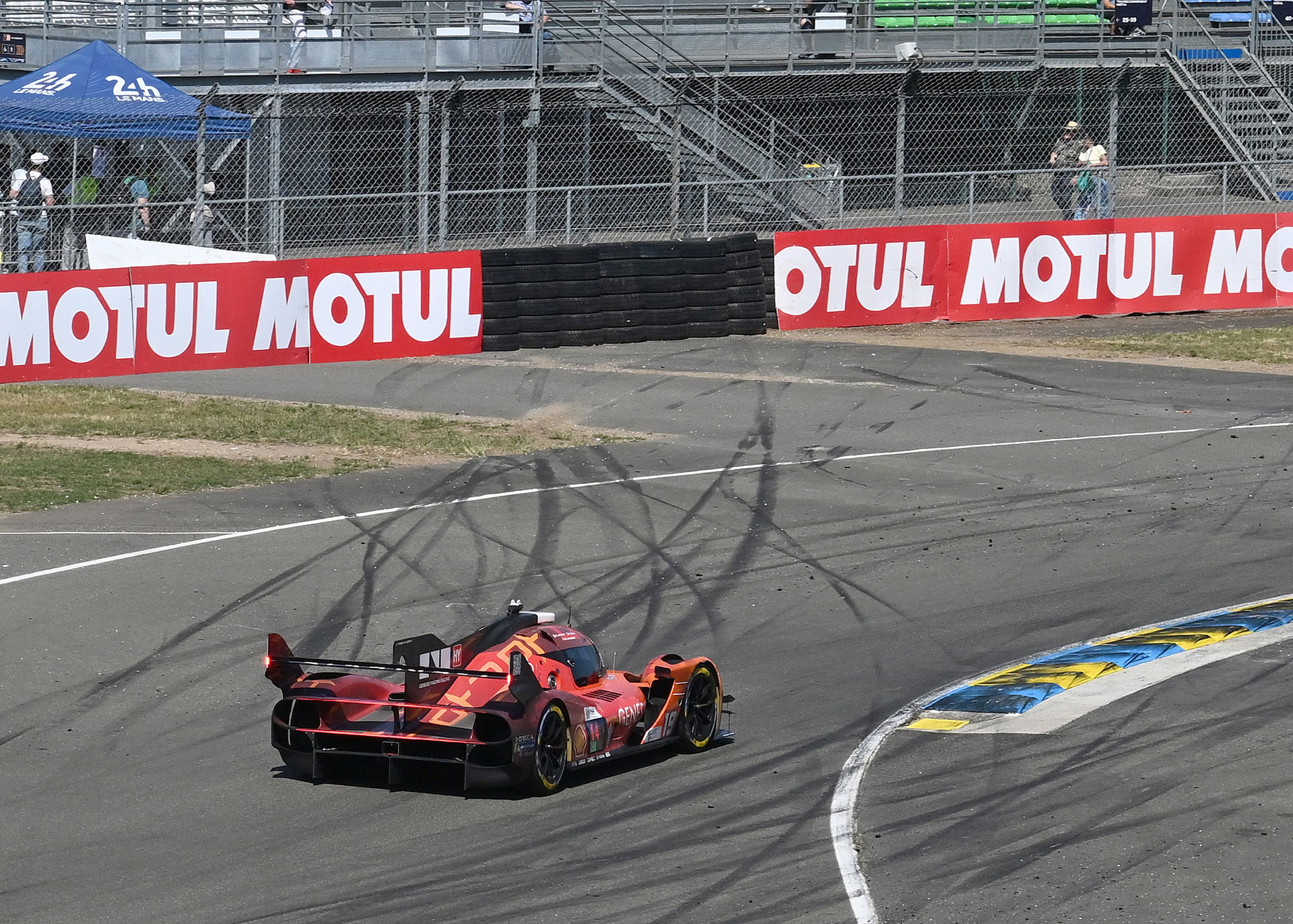 The GMR-001 #19 car passing through a circuit marked with tire tracks.