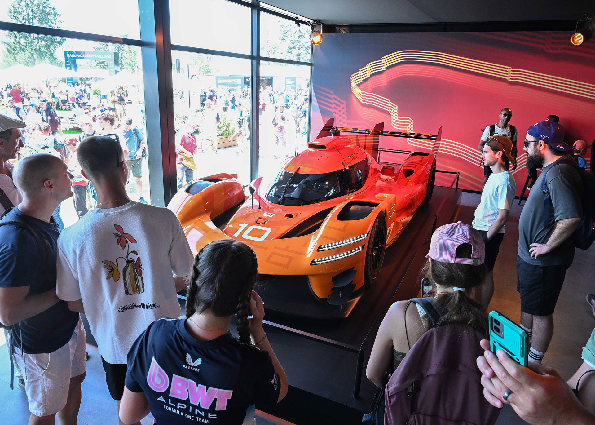 People looking at the displayed GMR-001 vehicle.