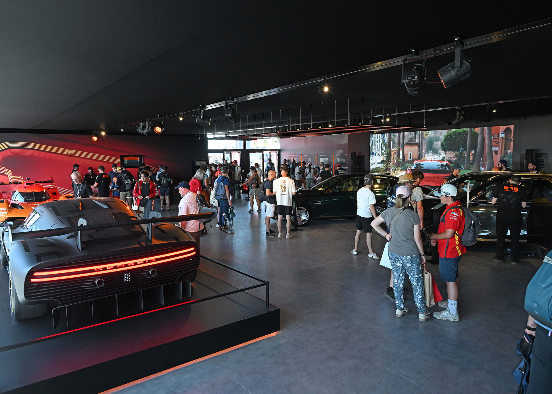 People viewing the Genesis vehicles displayed in the exhibition hall.
