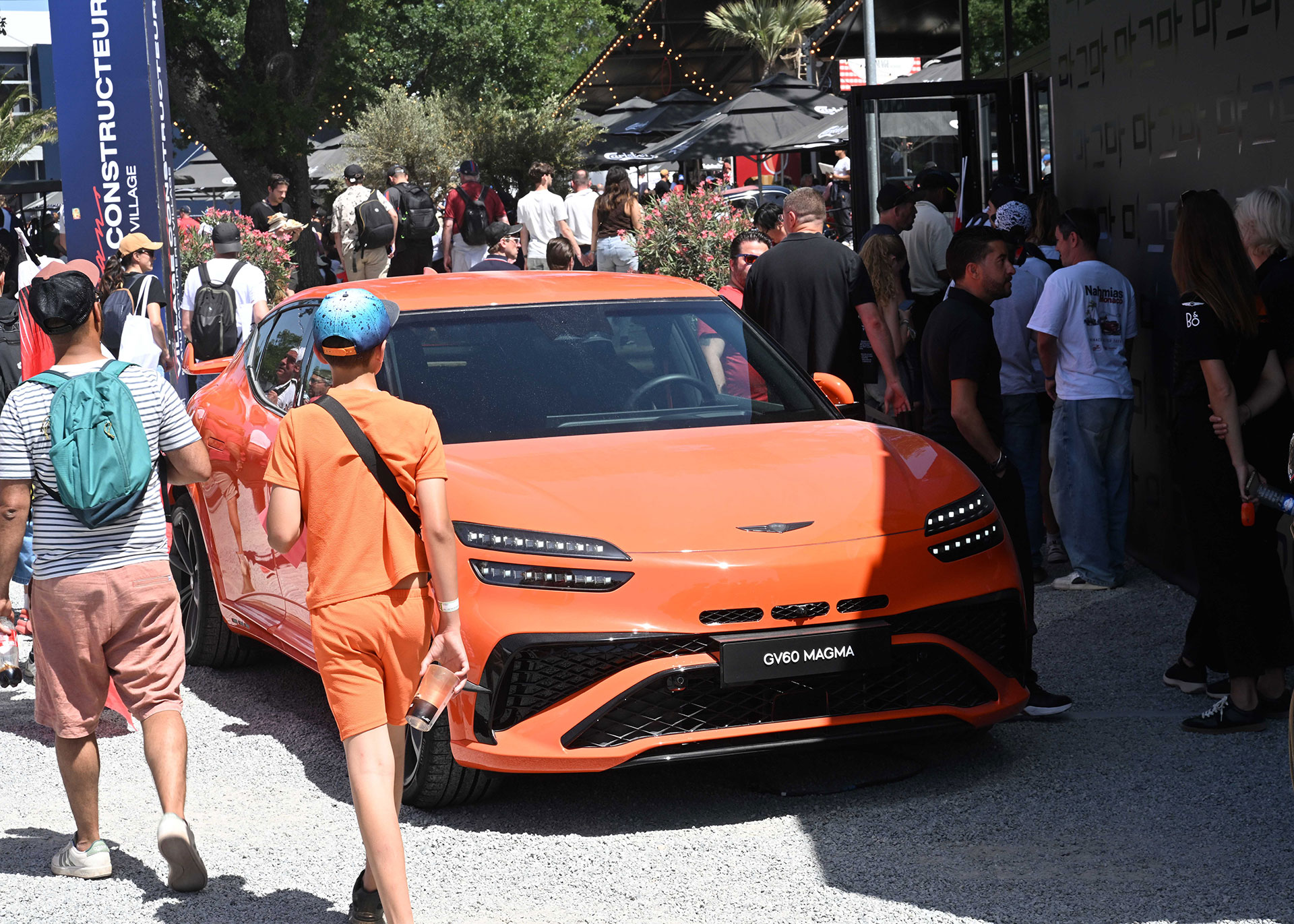 The front view of the Genesis GV60 Magma vehicle displayed outdoors.