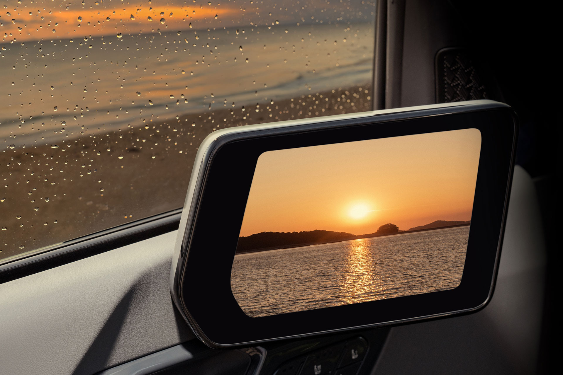Digital side mirrors of an EV9 GT with the sunset visible.