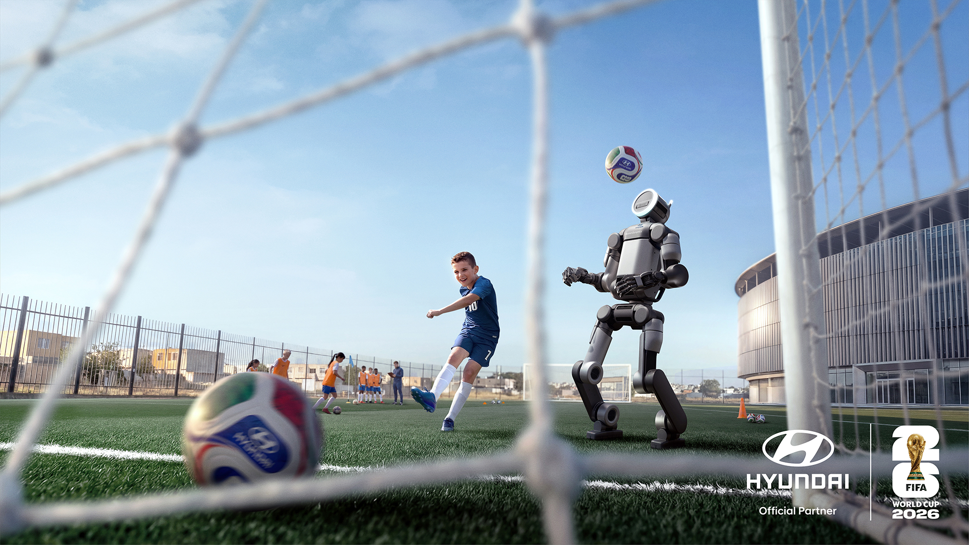 FIFA 월드컵 2026™ 현대자동차 공식 이미지 (골대 앞에서 아틀라스 로봇과 축구를 하고 있는 사람의 모습)