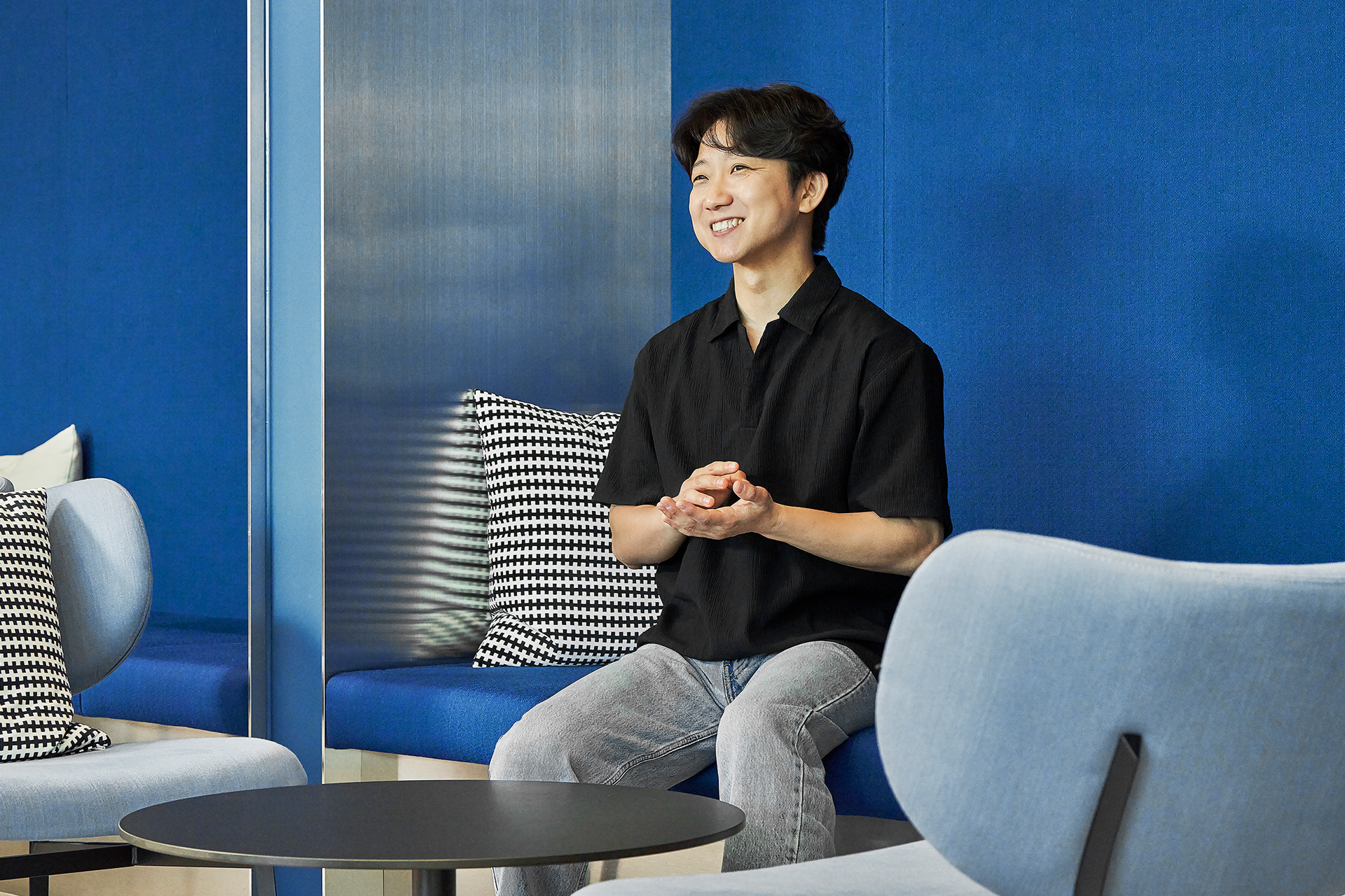 Myunggun Yoon, Senior Manager, seated on a sofa during an interview