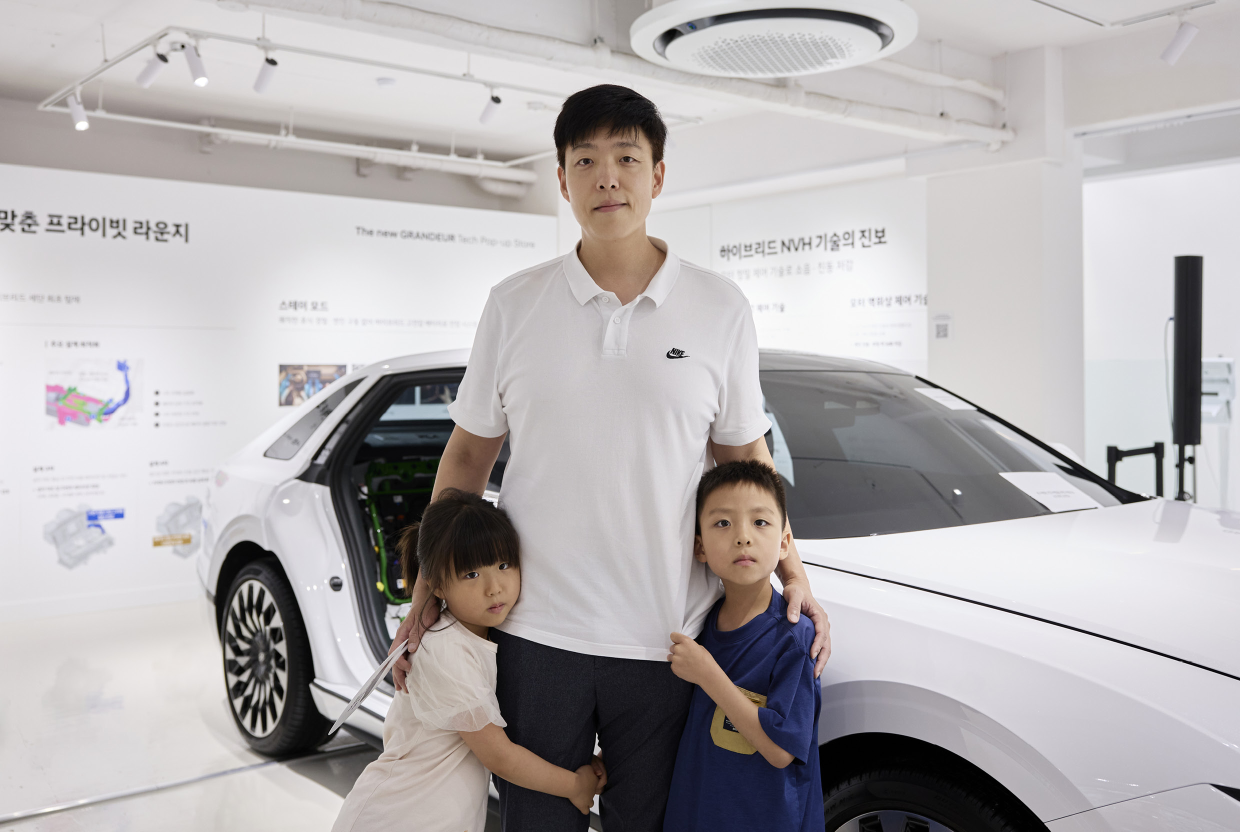 자녀와 함께 그랜저 테크 스토어를 둘러보는 일반 관람객의 모습