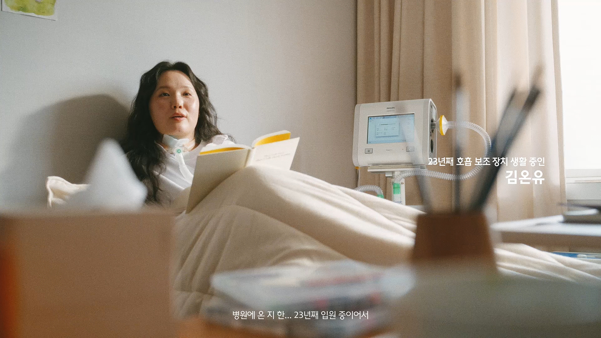이미지 텍스트: 23년째 호흡 보조 장치 생활 중인 김온유 / “병원에 온 지 한... 23년째 입원 중이어서”