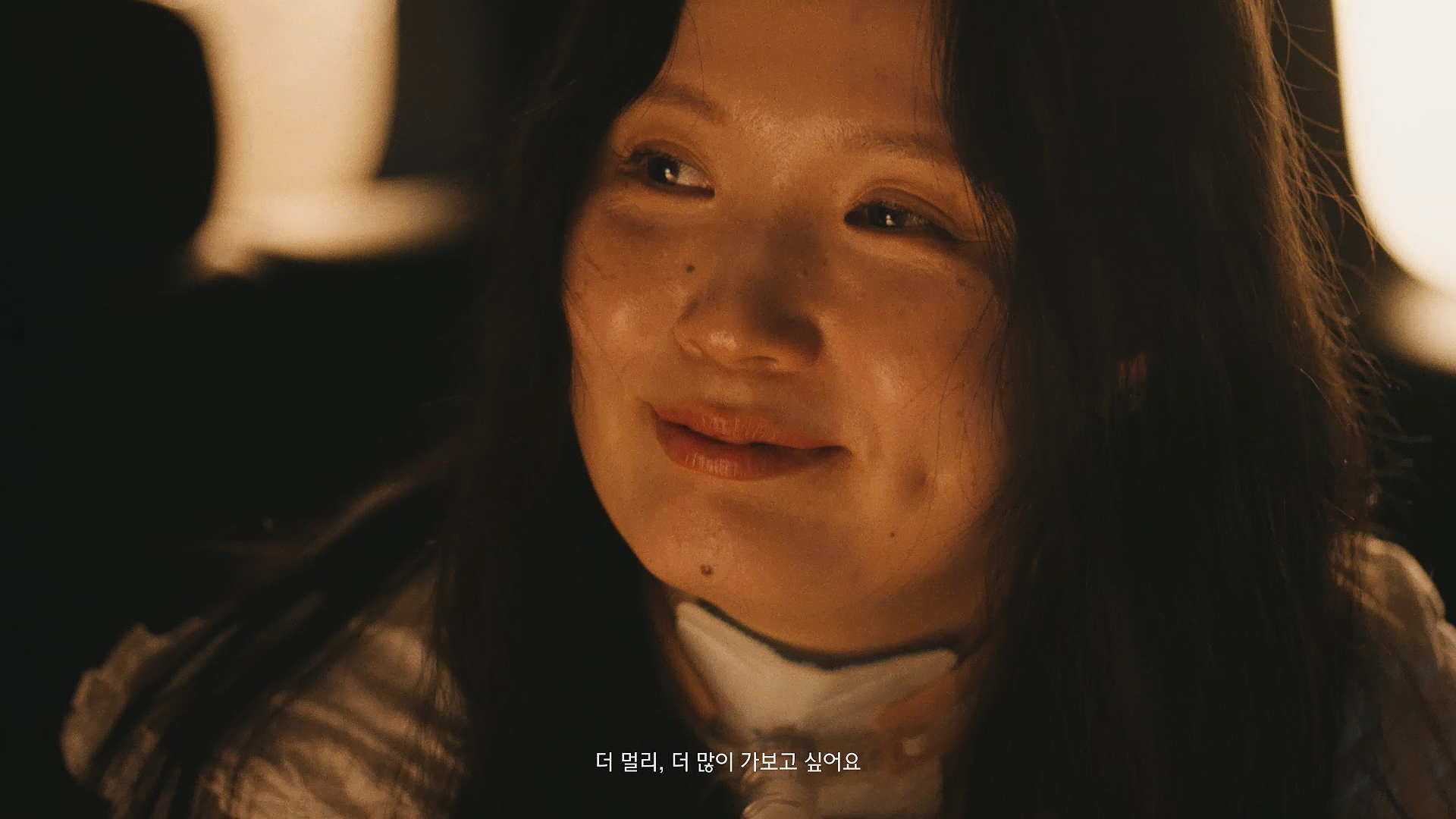 미소 짓고 있는 모습 (이미지 텍스트: 더 멀리, 더 많이 가보고 싶어요)