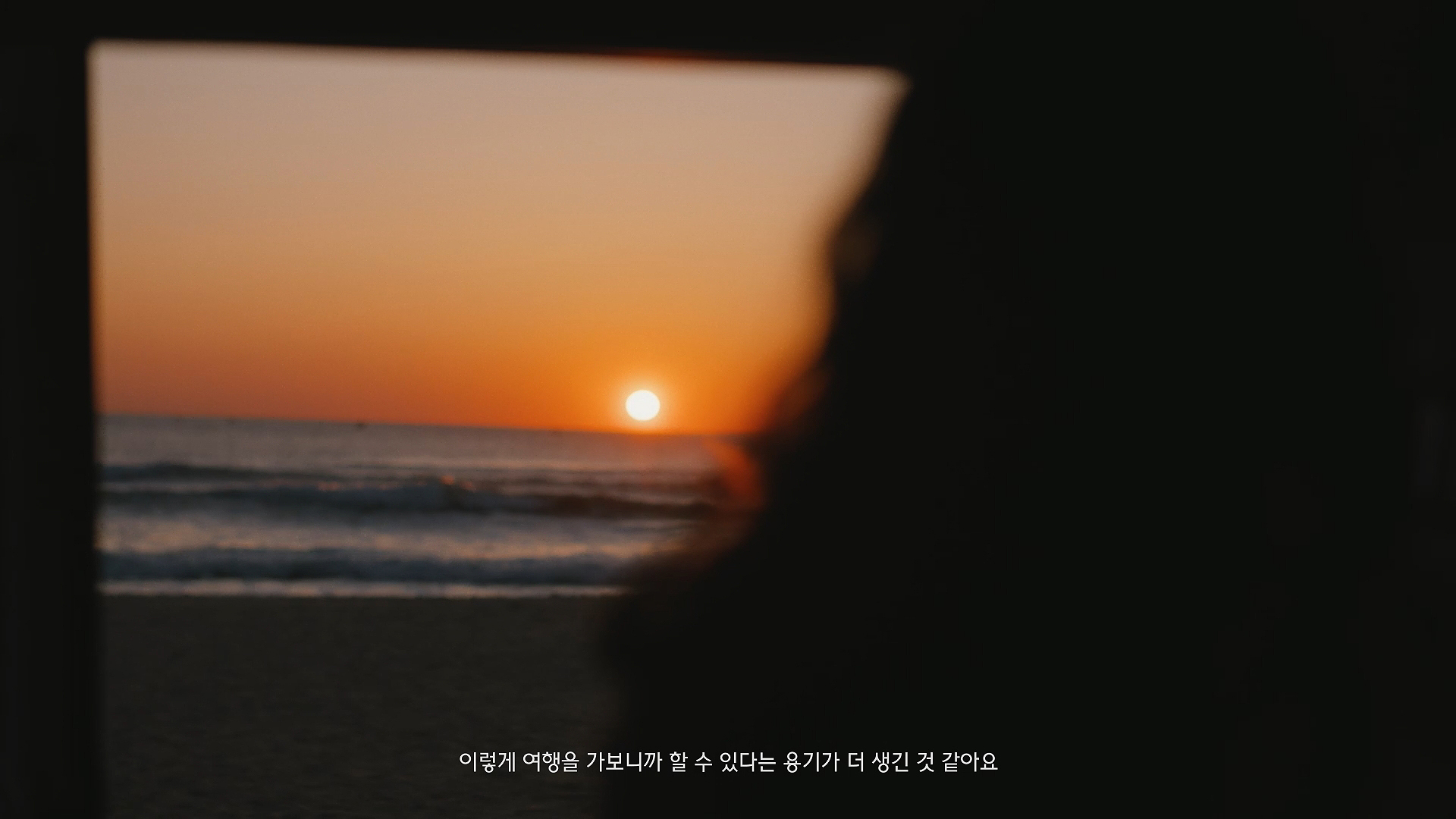 바다와 석양을 바라보고 있는 뒷모습 (이미지 텍스트: 이렇게 여행을 가보니까 할 수 있다는 용기가 더 생긴 것 같아요)