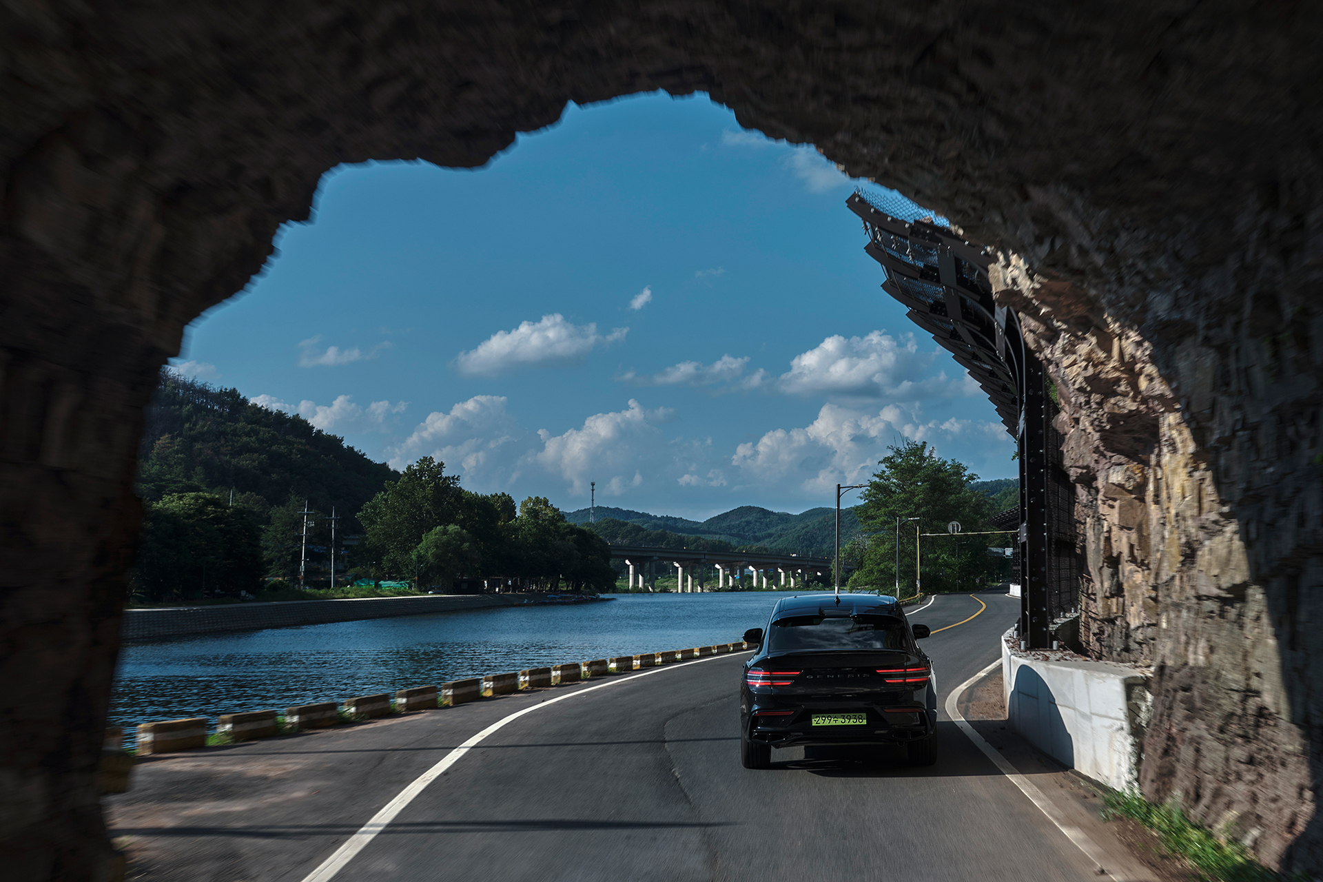 Genesis GV80 Coupe driving through a stone-arched tunnel