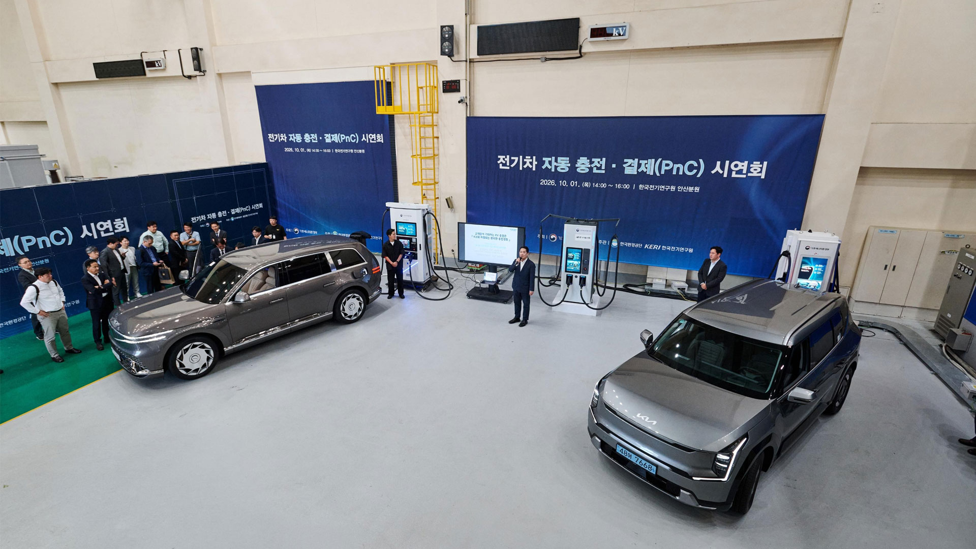 1일(목) 경기 안산시 소재 한국전기연구원 안산분원에서 개최된 국가 PnC 현장 시연회에서 제네시스 플래그십 전동화 SUV ‘GV90’(왼쪽)와 기아 ‘EV9’을 활용한 시연이 진행되는 가운데, 박종명 현대자동차·기아 EV충전혁신팀 팀장이 PnC기술에 대해 설명하고 있다.