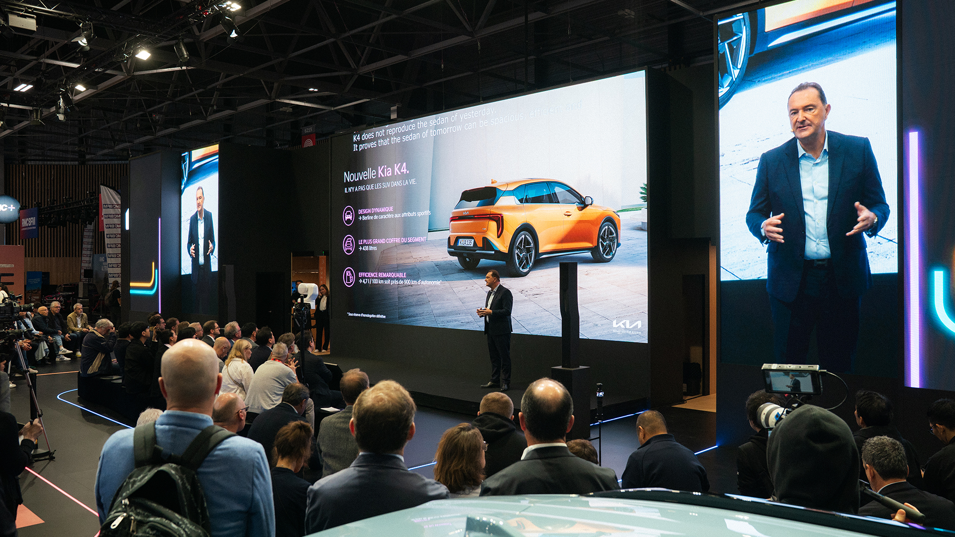 Kia K4 presentation slide with presenter and audience at press conference