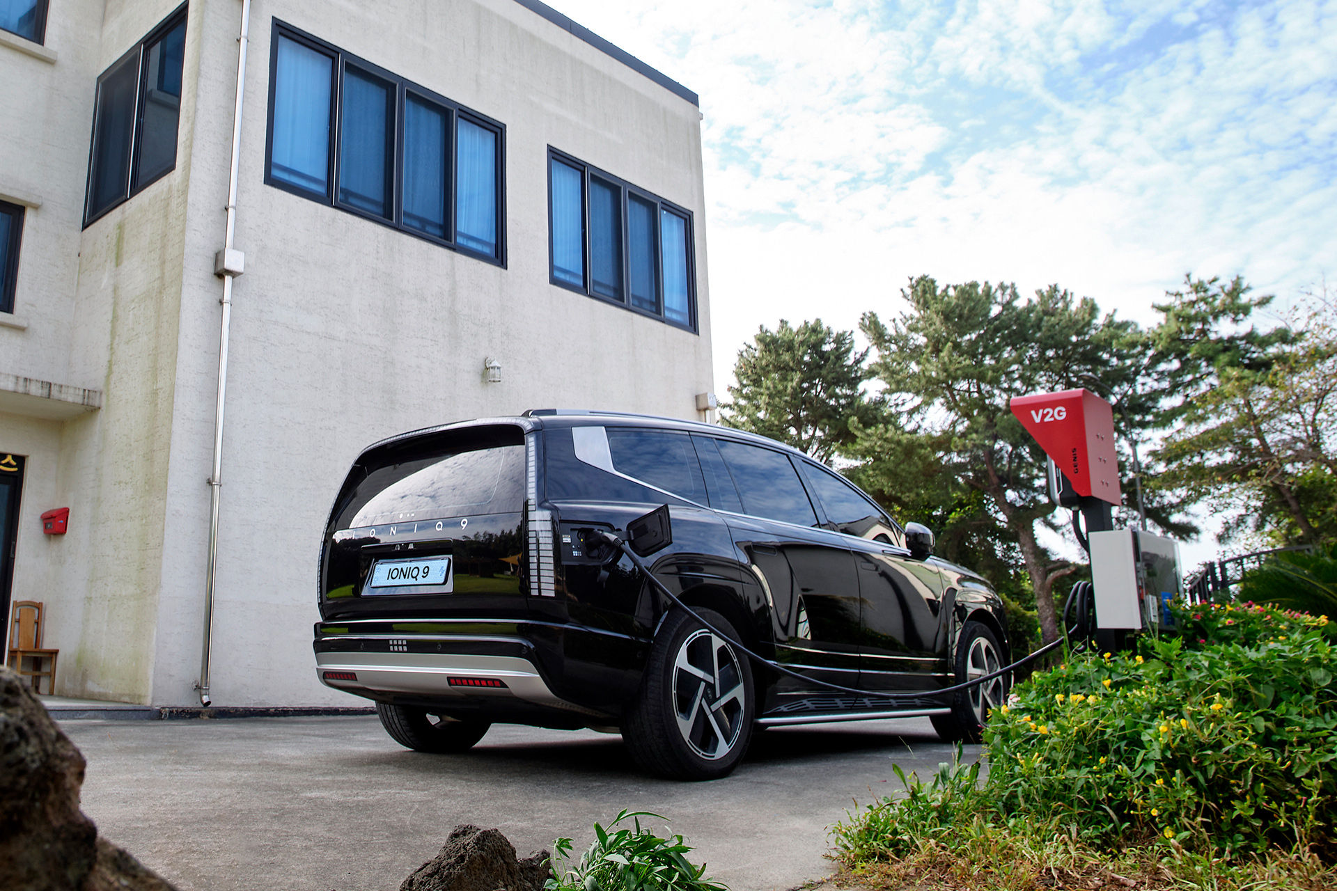 Electric vehicle parked at a charging station in front of a building