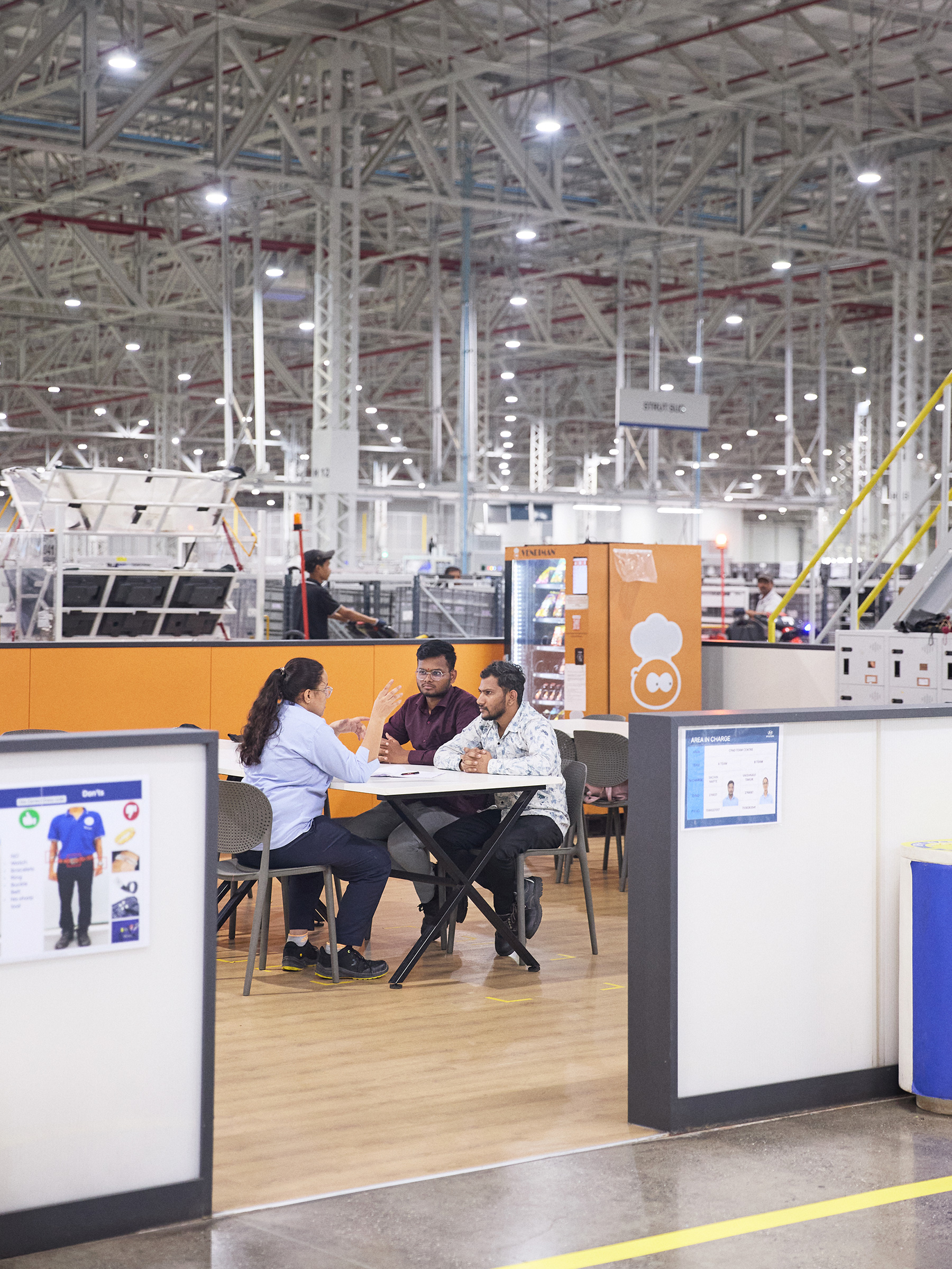 Employees having a meeting at an automotive manufacturing plant