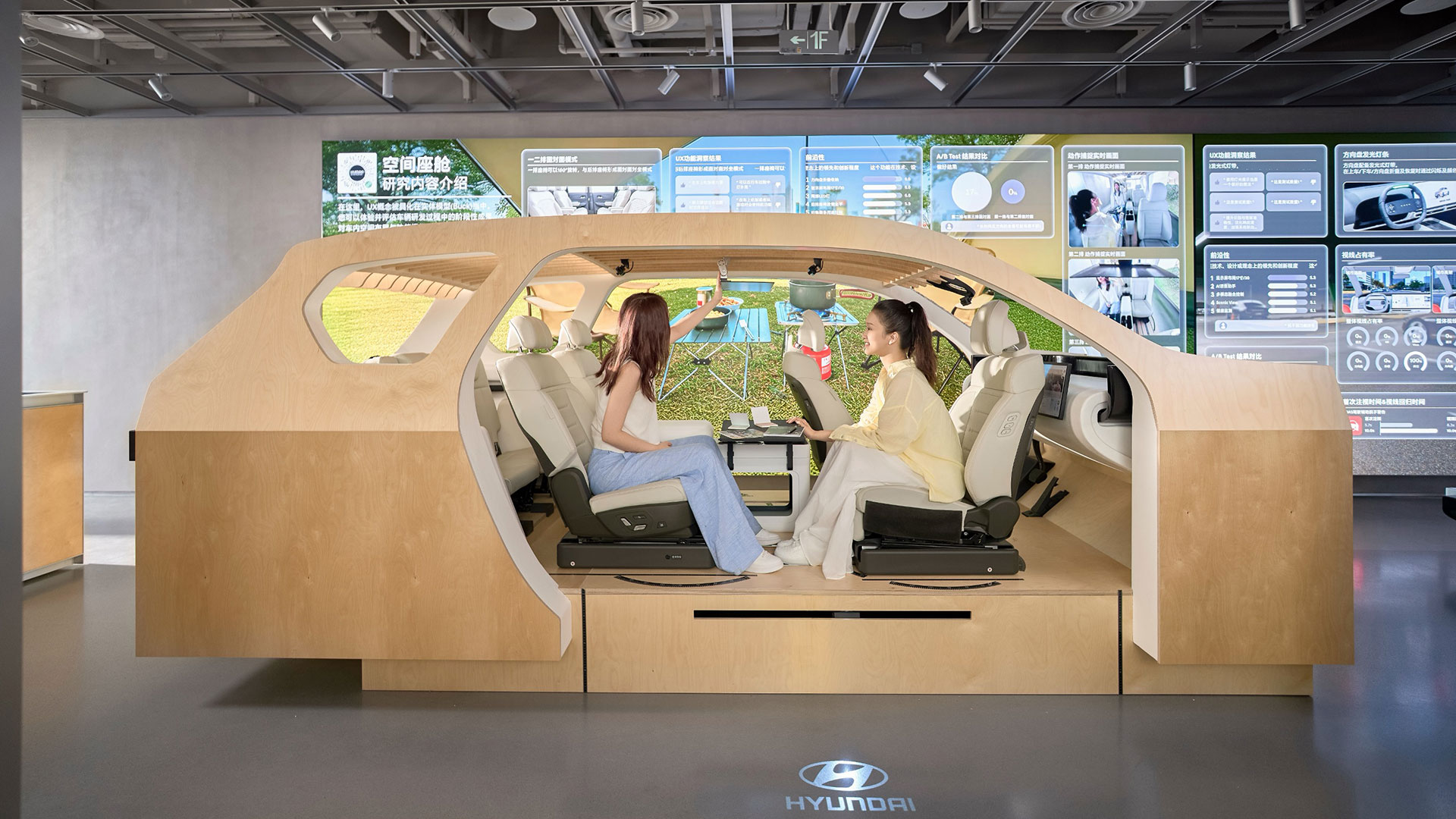 UX 테스트 존에 전시된 나무로 만든 스터디 벅(Study Buck)에서 방문객들이 마주 앉아 대면 모드를 체험하는 모습